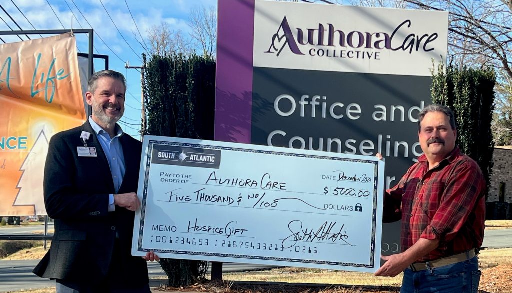 Representative from AuthoraCare Receiving a Check From South Atlantic LLC
