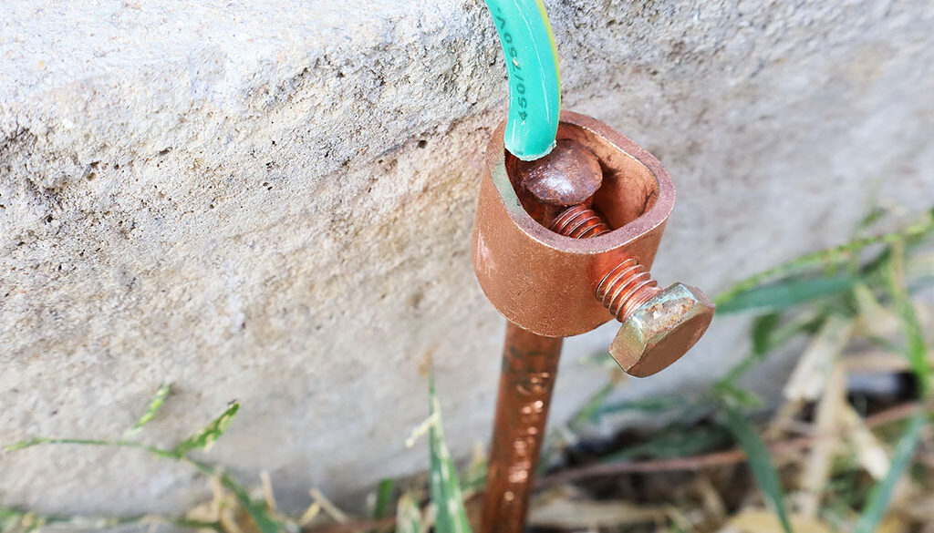 Closeup Of A Copper Grounding Rod Placed Into The Ground Beside A Concrete Slab Ground Rod Durability