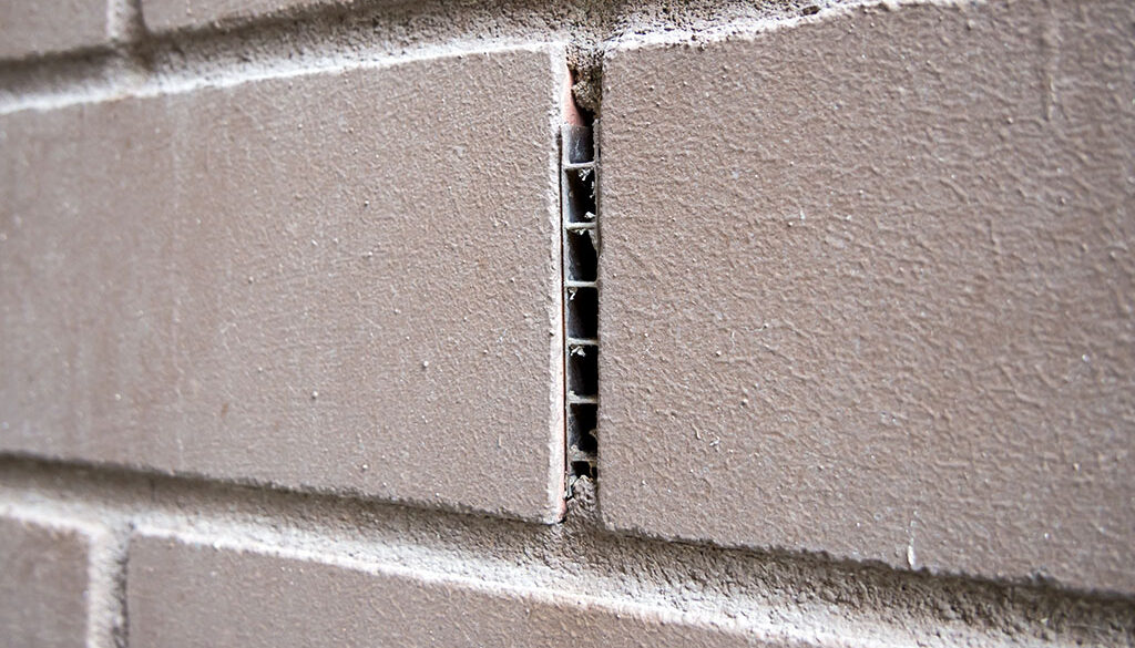 Closeup of a Gray Brick Wall With a Weep Hole What Are Weep Vents