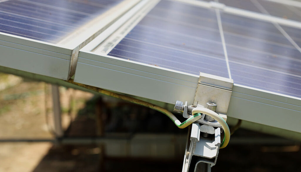 Closeup Of Grounding Wires Mounted To The Side Of Solar Panels Grounding Requirements For Solar Panels