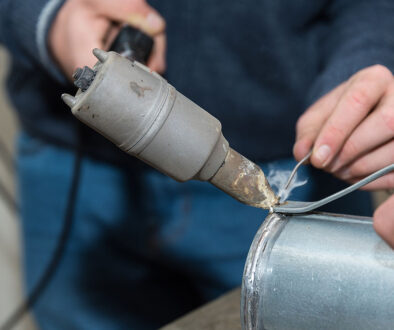 Closeup Of A Man Using A Soldering Iron On Galvanized Steel Can You Solder Galvanized Steel