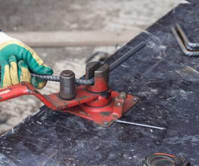 Closeup Of A Worker Bending A Bar Of Galvanized Rebar With A Tool Bending Rebar After Galvanization