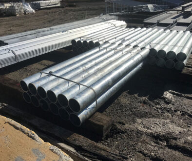 A Stack Of Galvanized Steel Pipes Lying On Top Of A Wooden Stand Outdoors Galvanized Steel Maintenance