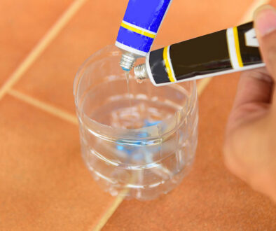 Closeup Of A Person Pouring Epoxy Adhesive Into A Plastic Bottle Adhesives For Galvanized Steel